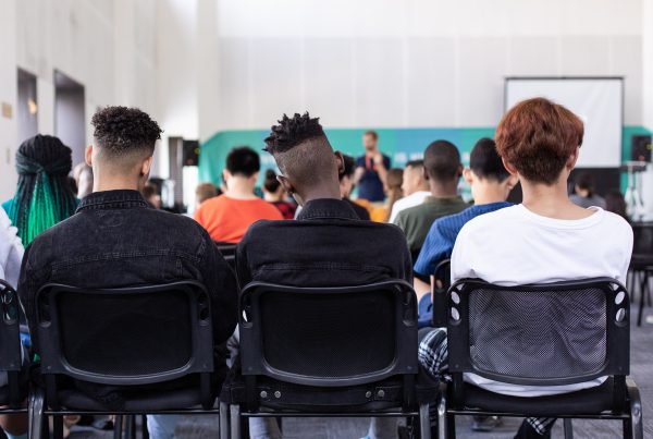 Learners listening to a teacher in a classroom,