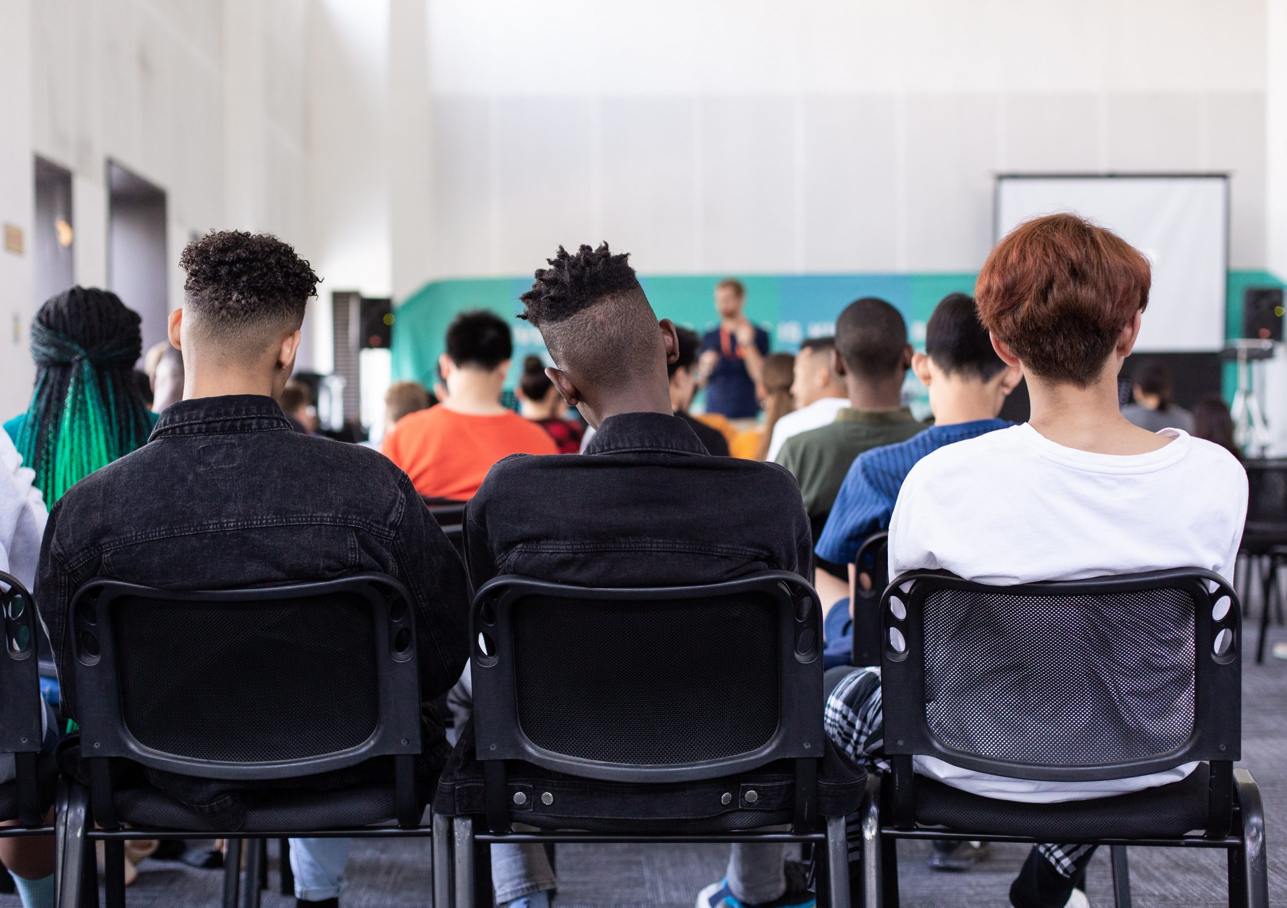 Learners listening to a teacher in a classroom,
