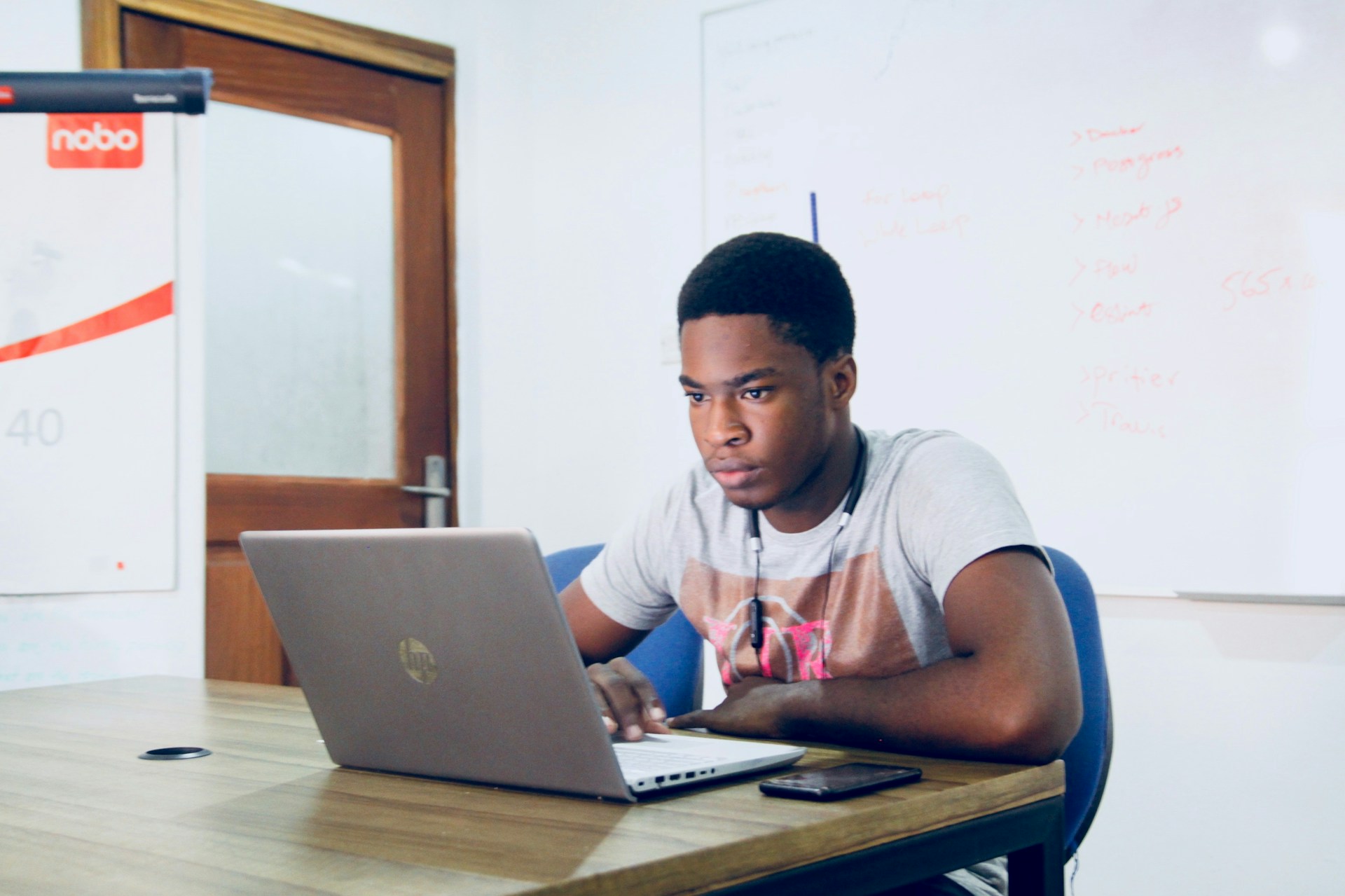 Student sat at desk using a laptop.